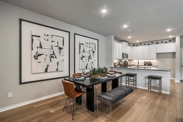 a kitchen with a table chairs stove and wooden floor