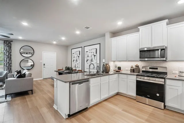 a kitchen with stainless steel appliances granite countertop a stove and a sink