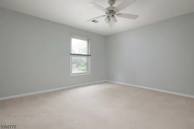 an empty room with a window and a fan