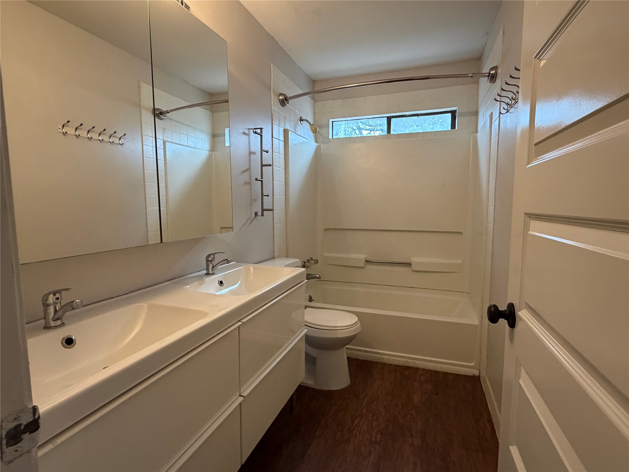 7404 Bethune Avenue Austin, TX 78752 - Photo 10 of 16 Full bath featuring double vanity, shower / bathtub combination, and dark wood-type flooring