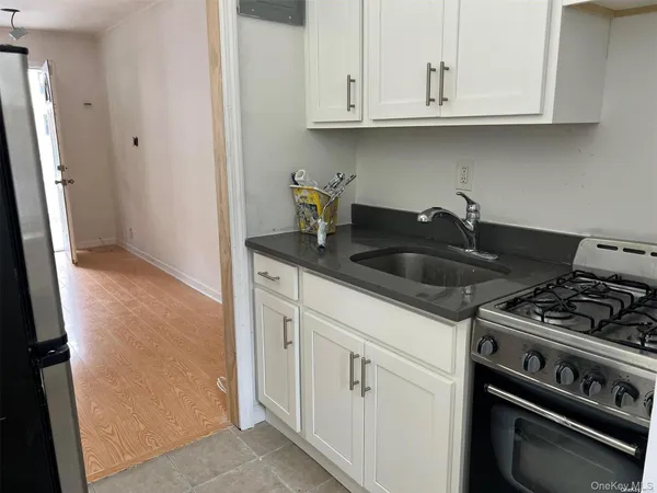 a kitchen with white cabinets and a stove with a sink