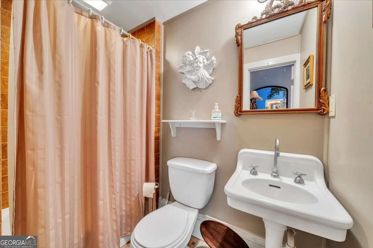 212 East Union Street Vienna, GA 31092 - Photo 9 of 62 a bathroom with a toilet a sink and a mirror