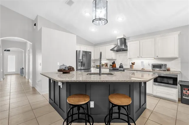 a kitchen with stainless steel appliances a table chairs and white cabinets