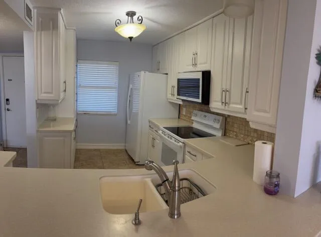 a kitchen with a refrigerator and a sink