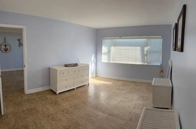 a view of an empty room with a fireplace and a window
