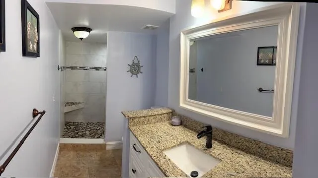 a bathroom with a granite countertop sink a mirror and shower