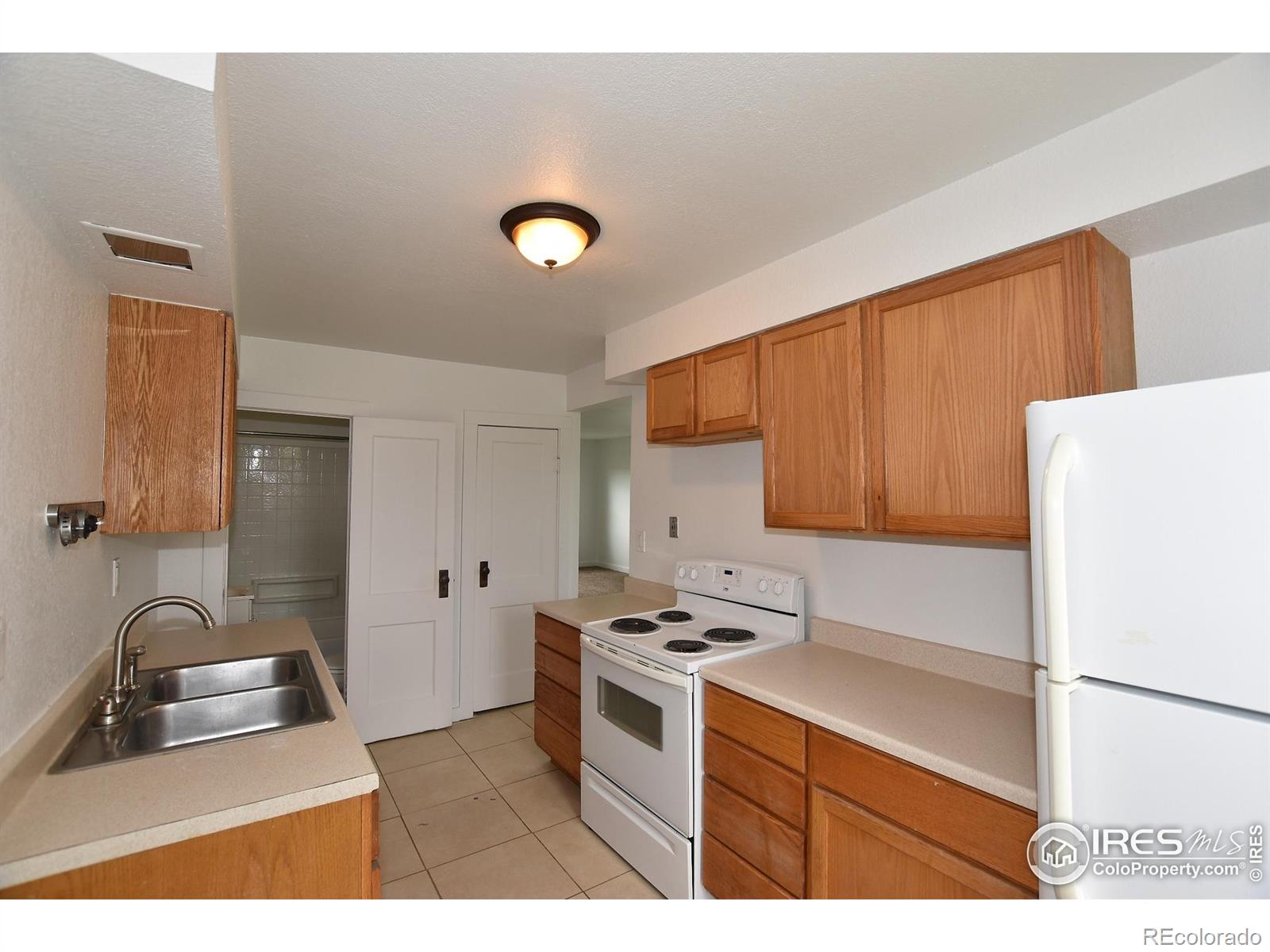 1340 North Taft Hill Road Fort Collins, CO 80521 - Photo 35 of 40 a kitchen with a sink a stove and refrigerator