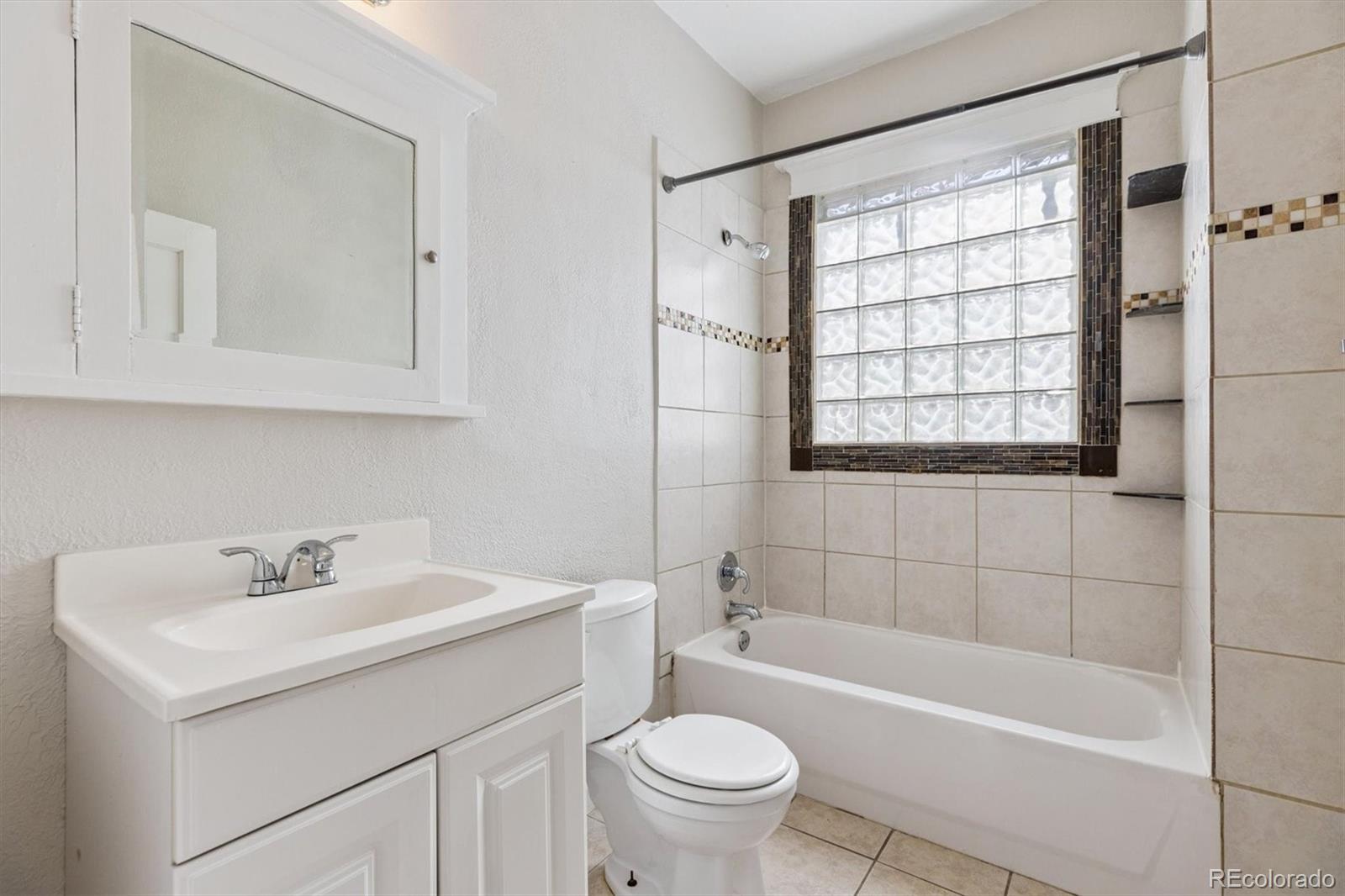 1411-1419 Meade Street Denver, CO 80204 - Photo 11 of 20 a bathroom with a sink a toilet and shower