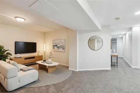a living room with furniture a flat screen tv and a large window