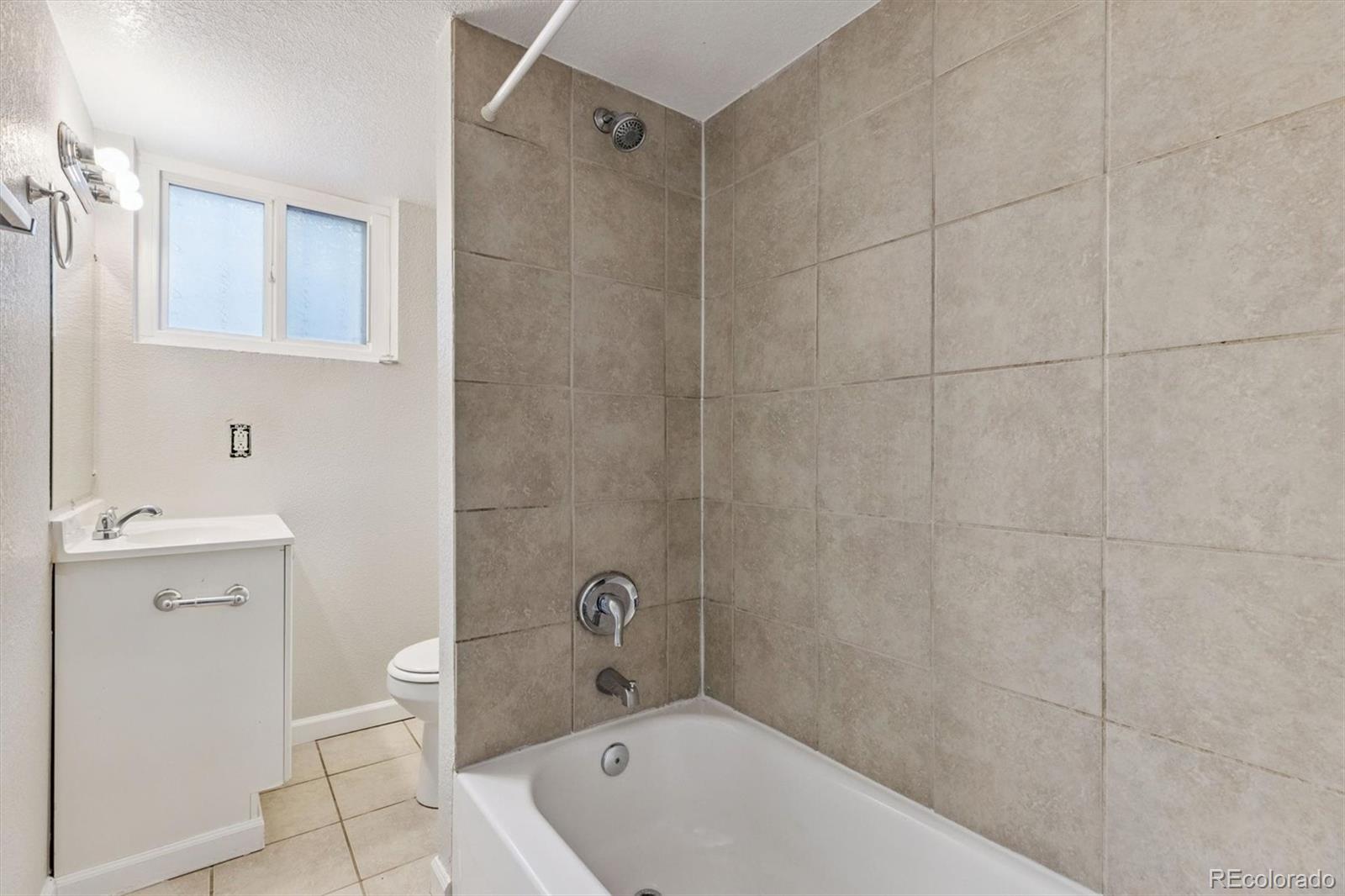 1411-1419 Meade Street Denver, CO 80204 - Photo 15 of 20 a bathroom with a sink a toilet and shower