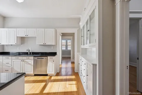 a kitchen with stainless steel appliances granite countertop a refrigerator and white cabinets