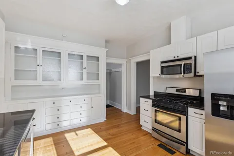 a kitchen with granite countertop white cabinets and stainless steel appliances
