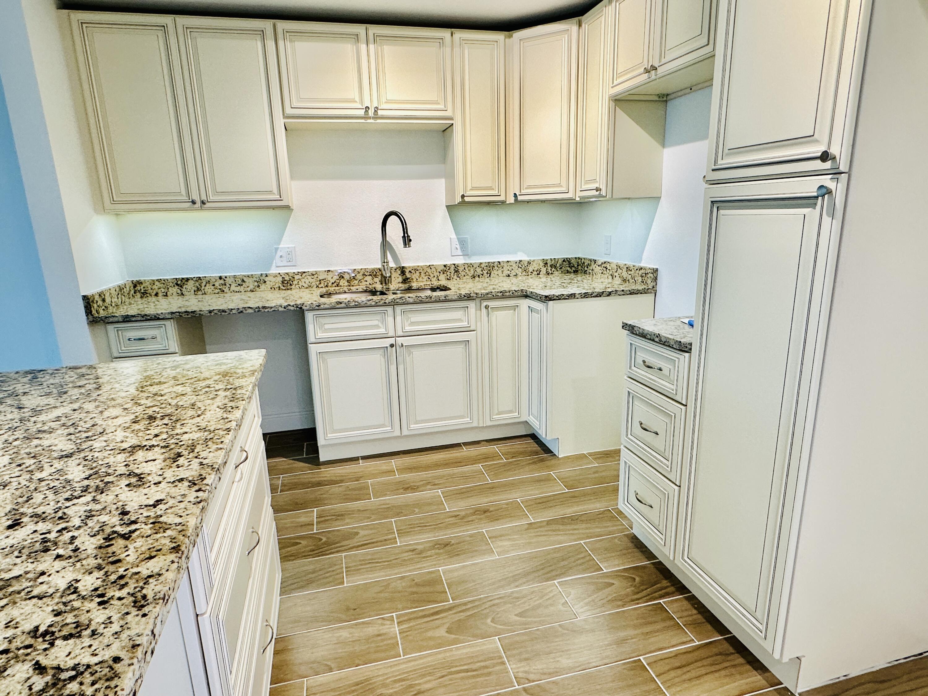a kitchen with granite countertop a sink and cabinets