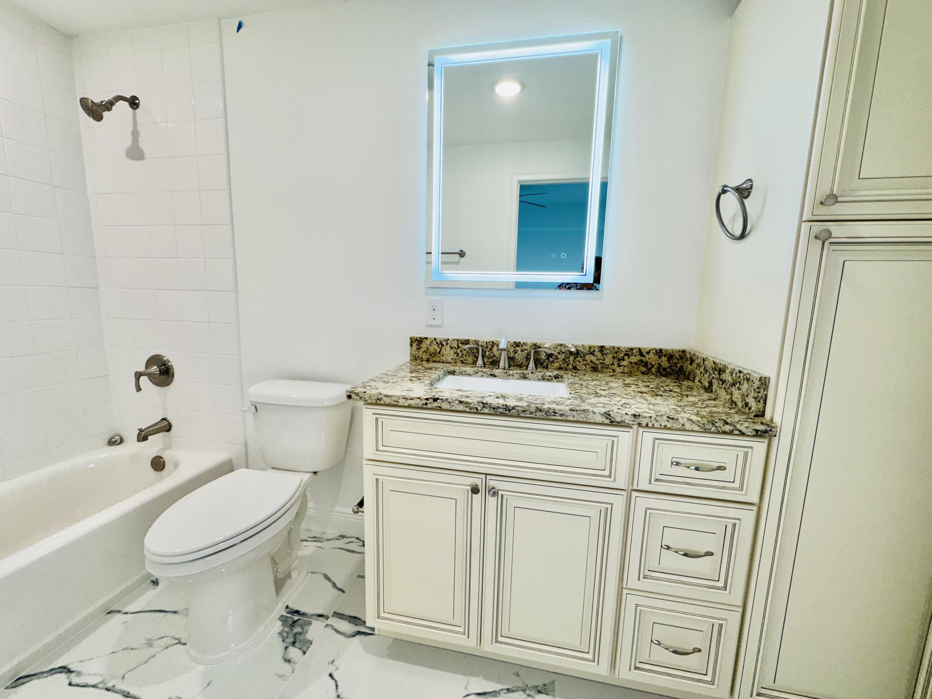 735 Pilot Lane, Unit 314 Merritt Island, FL 32952 - Photo 12 of 41 a bathroom with a granite countertop toilet a sink and a mirror