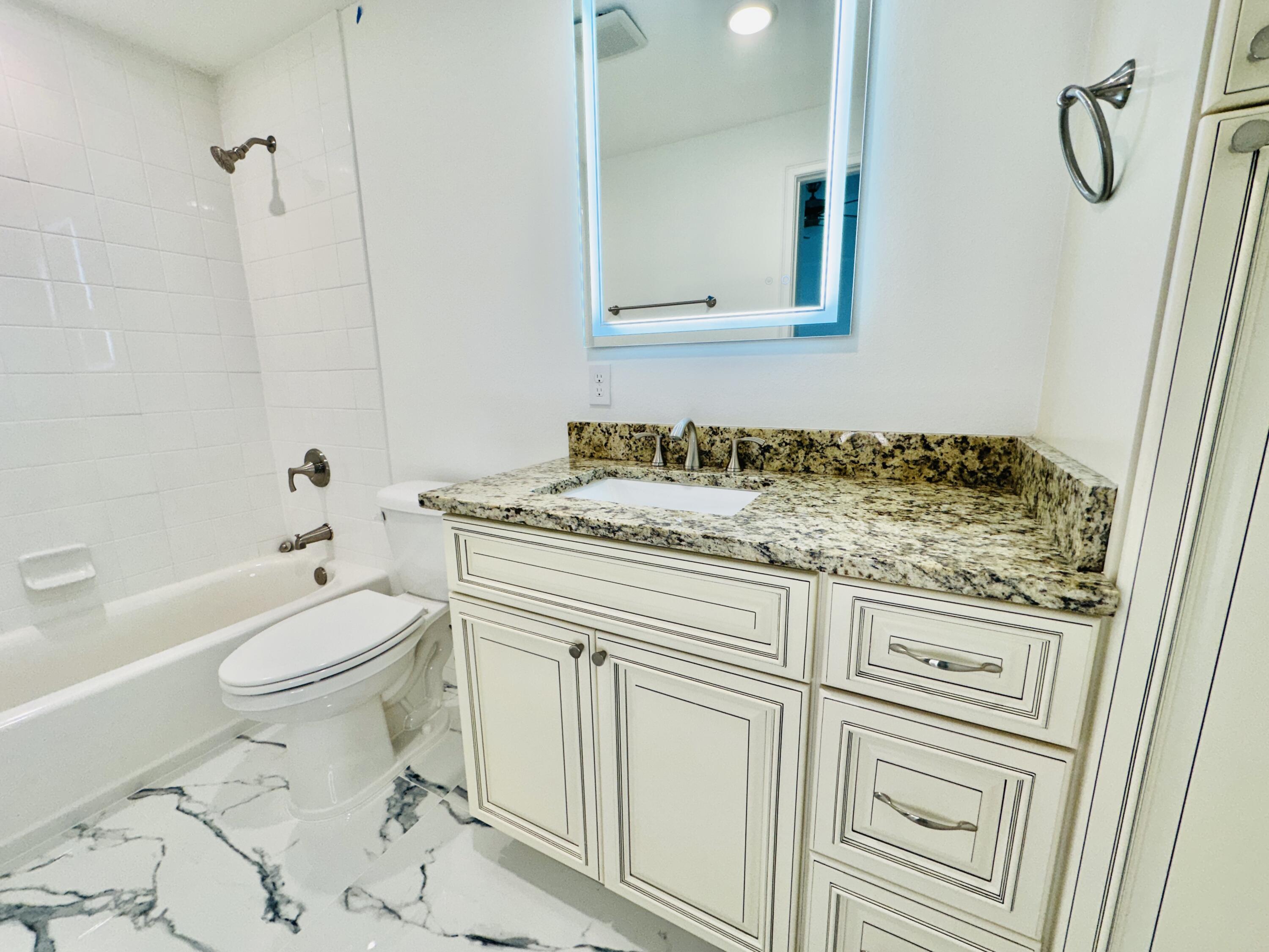 735 Pilot Lane, Unit 314 Merritt Island, FL 32952 - Photo 13 of 41 a bathroom with a granite countertop sink toilet and shower