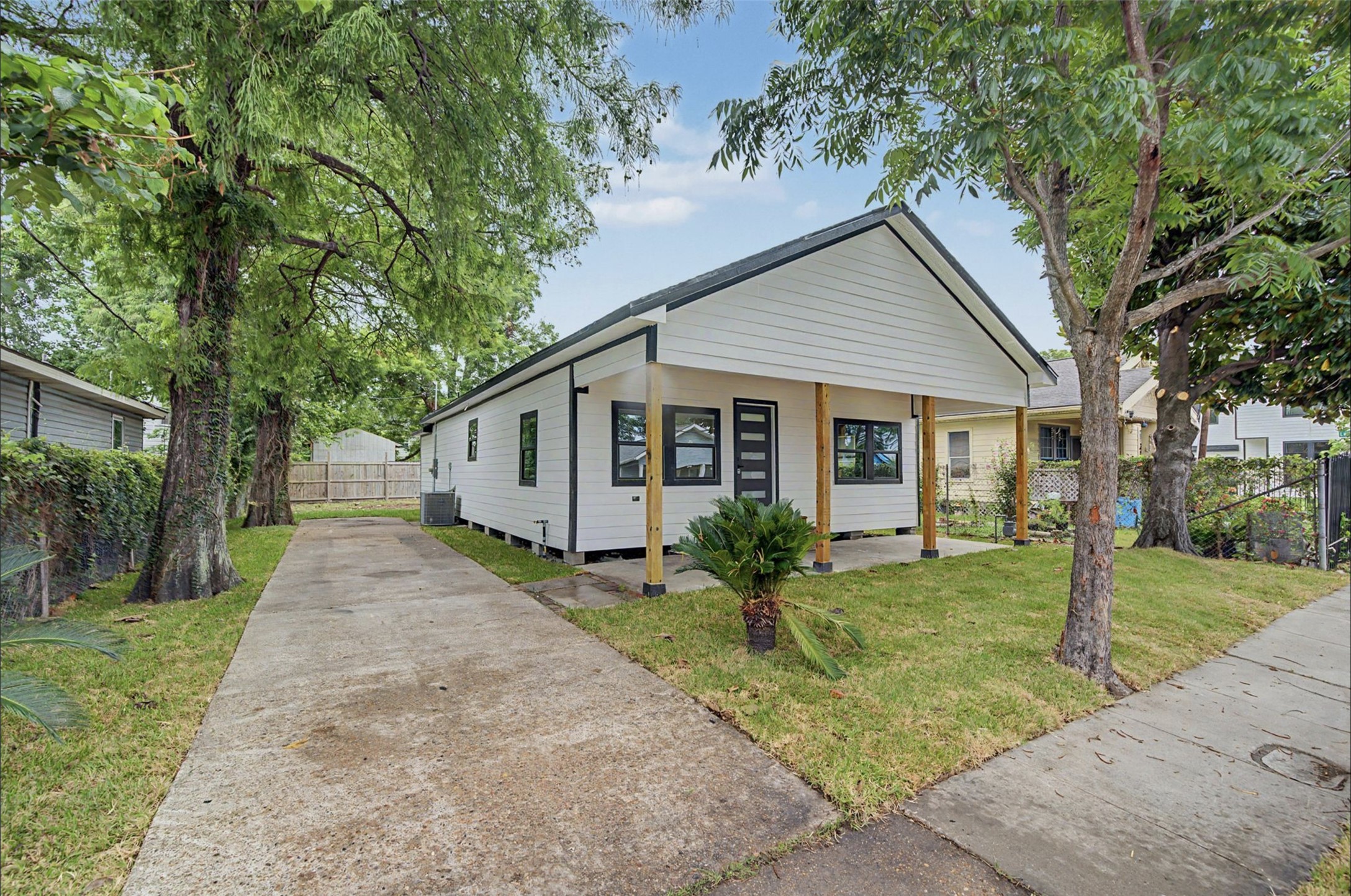 2338 Lidstone Street Houston, TX 77023 - Photo 5 of 17 Charming single-story home with a welcoming front porch, a long driveway, and is surrounded by mature trees, providing shade and privacy, offering great curb appeal.