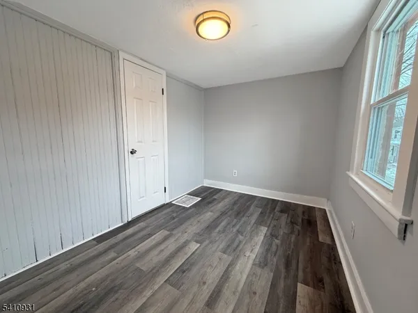 a view of a room with wooden floor and window