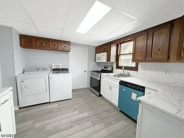 a kitchen with granite countertop a stove top oven sink and cabinets