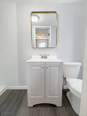 a bathroom with a toilet sink vanity and mirror