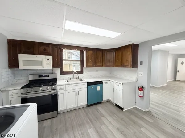a kitchen with granite countertop a stove top oven sink and cabinets