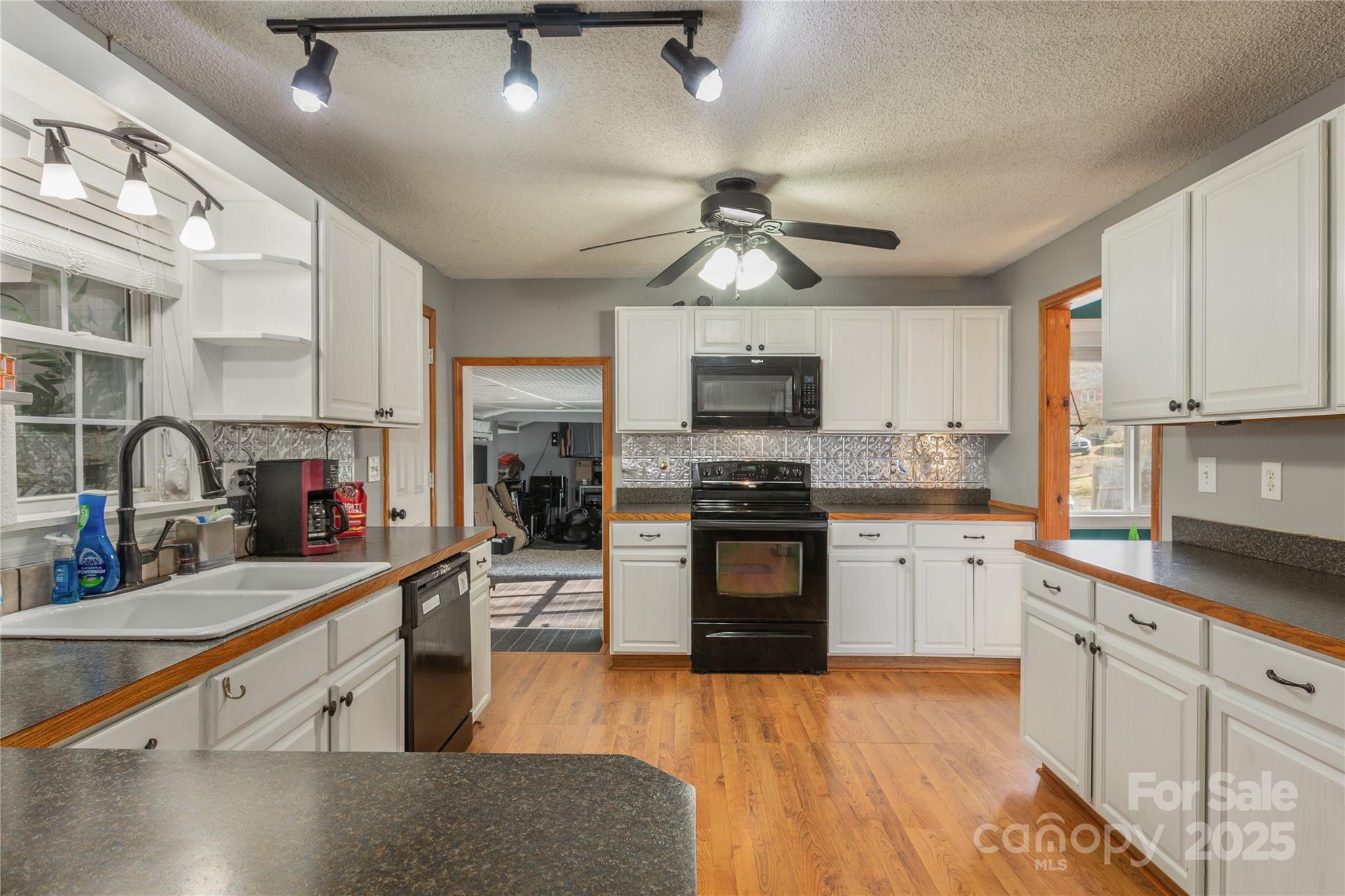333 Oakview Park Road Asheville, NC 28803 - Photo 6 of 31 a kitchen with stainless steel appliances granite countertop a sink dishwasher stove top oven and cabinets with wooden floor