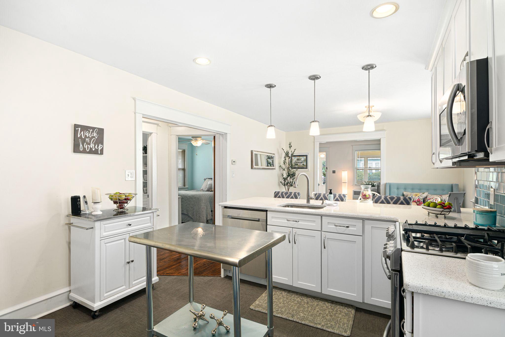 23 Ormond Avenue Haddon Township, NJ 08107 - Photo 11 of 34 a kitchen with white cabinets stainless steel appliances and dining table