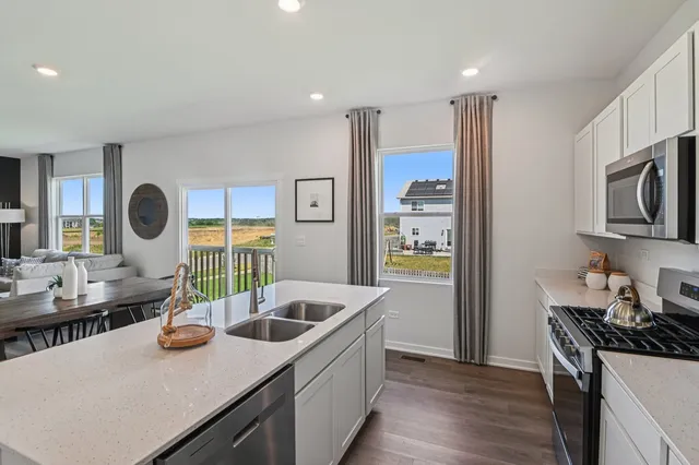 a kitchen with stainless steel appliances kitchen island granite countertop a sink a stove and wooden cabinets