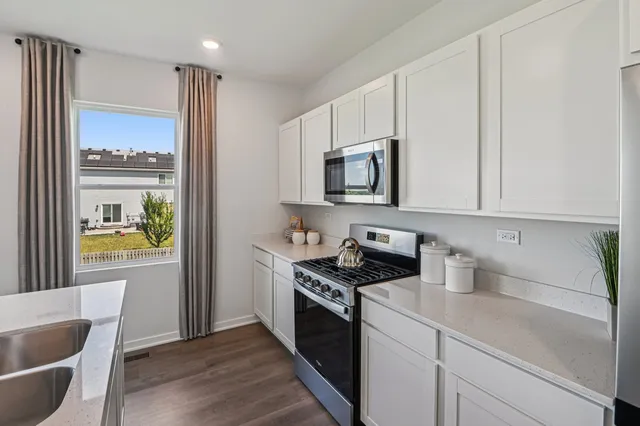 a kitchen with stainless steel appliances a white stove top oven and a sink