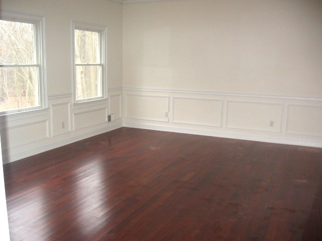 147 Millhurst Road Manalapan, NJ 07726 - Photo 2 of 3 an empty room with wooden floor and windows