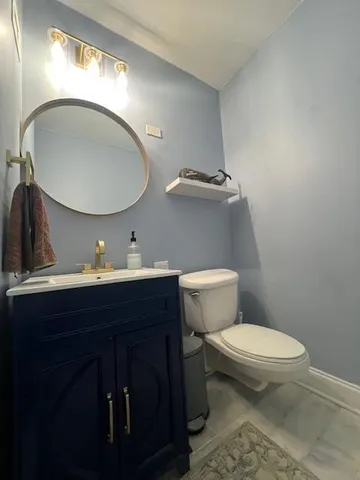a bathroom with a toilet a sink and mirror