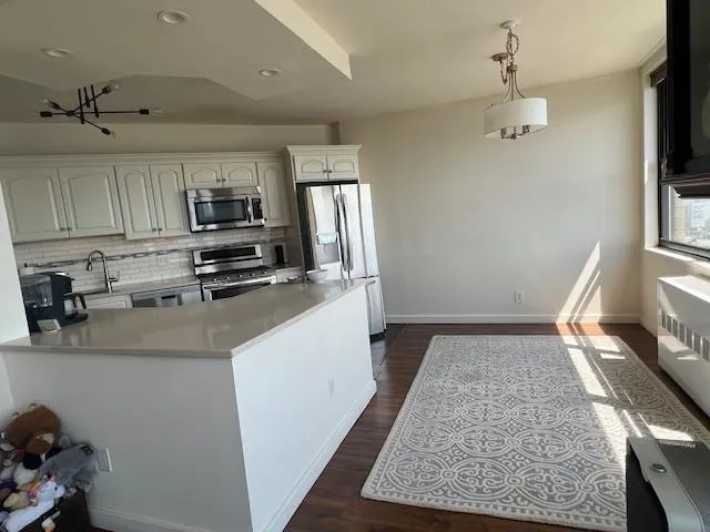 a kitchen with kitchen island a stove top oven a sink a counter space and cabinets