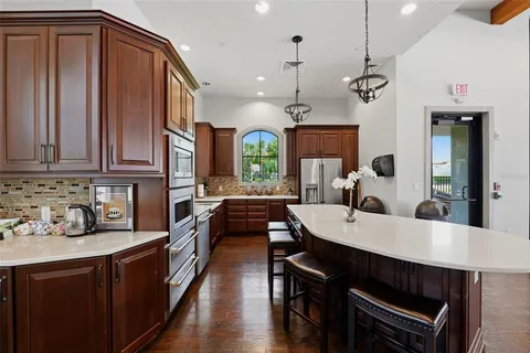 a large kitchen with lots of counter space a sink appliances and cabinets