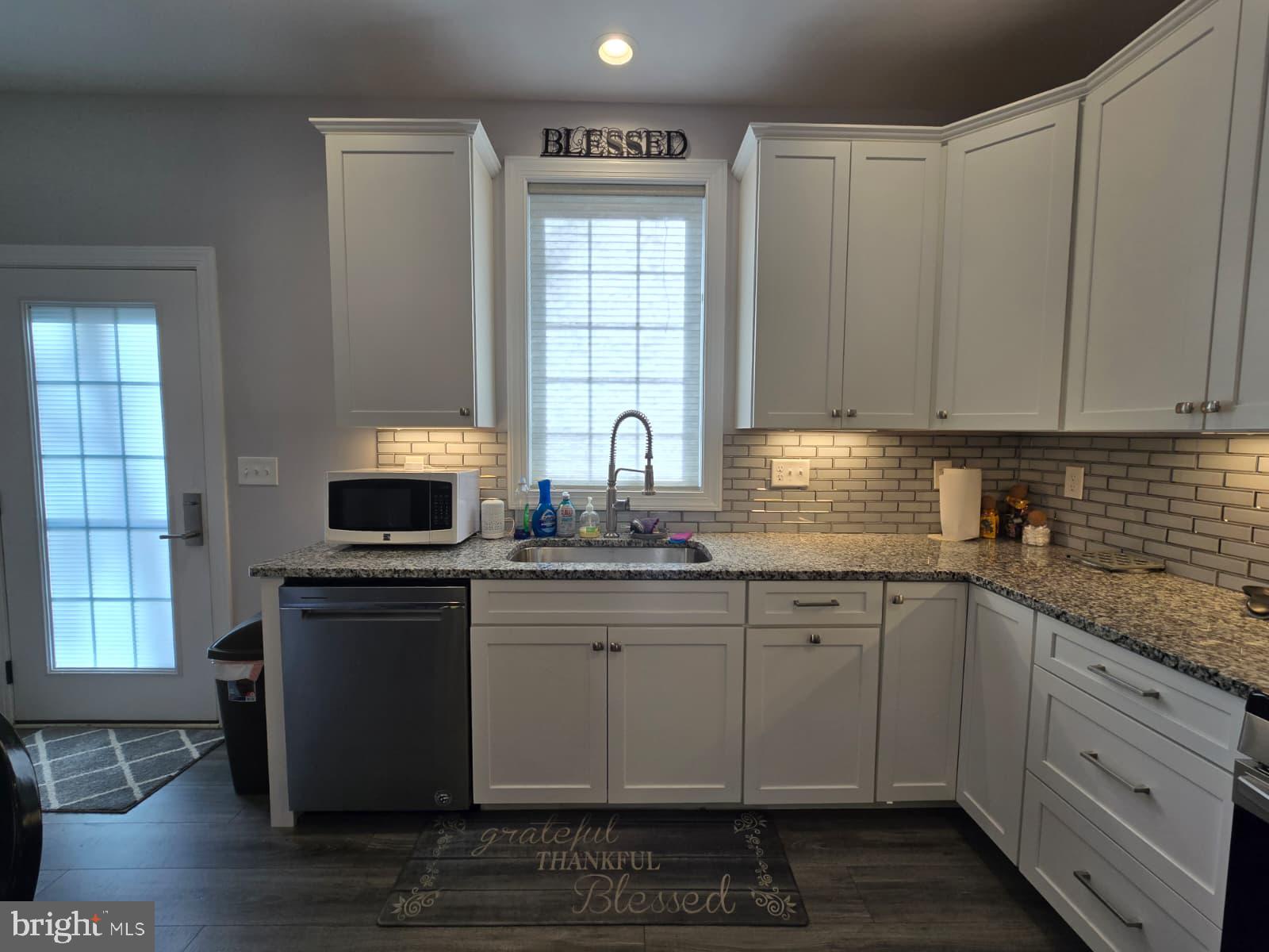 209 3rd Street Crumpton, MD 21628 - Photo 17 of 53 a kitchen with stainless steel appliances granite countertop a sink stove and cabinets