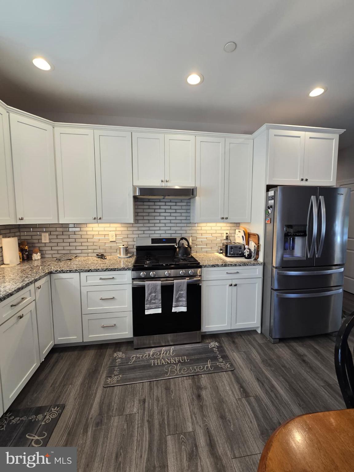 209 3rd Street Crumpton, MD 21628 - Photo 19 of 53 a kitchen with granite countertop white cabinets and stainless steel appliances