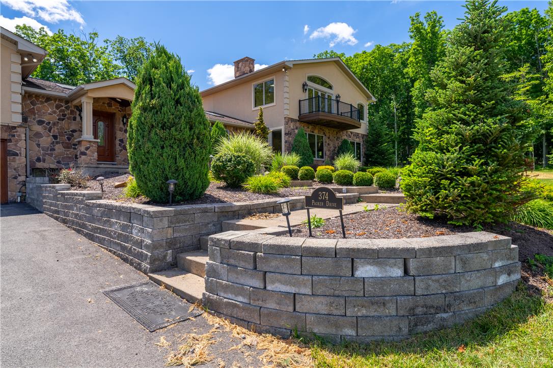 374 Packer Drive Weatherly, PA 18255 - Photo 3 of 36 Natural stone accents and mature landscaping adorn this captivating hillside residence, framed by lush trees.
