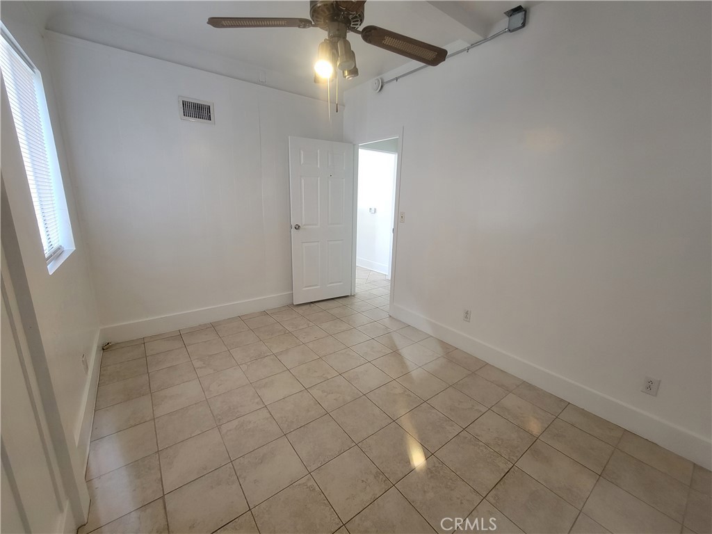 2047 Cambridge Street, Unit A Los Angeles, CA 90006 - Photo 6 of 10 an empty room with a ceiling fan and window