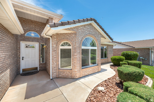805 South River Road, Unit 70 St. George, UT 84790 - Photo 6 of 38 Brick exterior with a white entry door, arched transom window, and an arched window with blinds