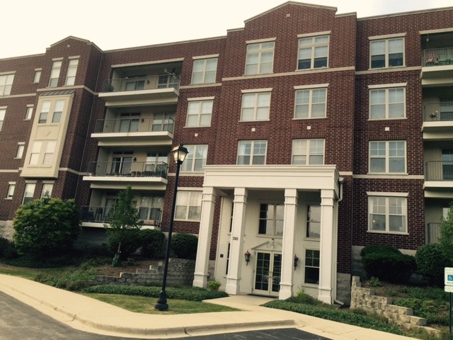 a front view of a residential apartment building with a yard