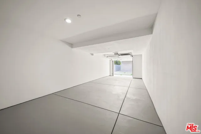 a view of an empty room with cabinet and door