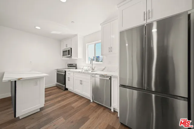 a kitchen with a refrigerator sink and cabinets