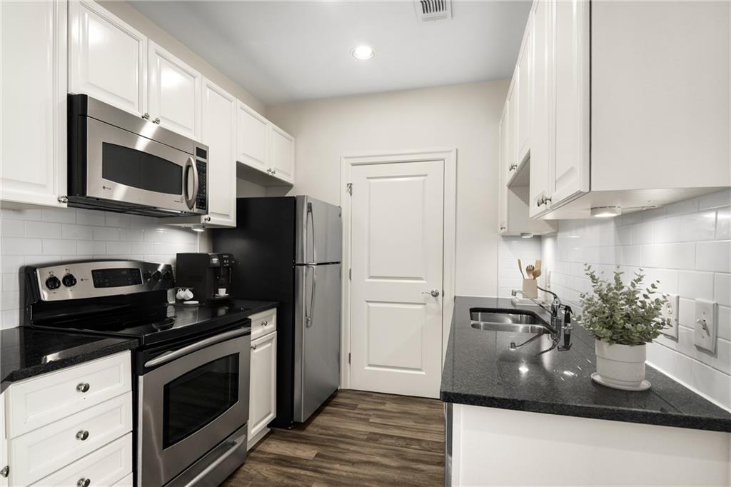 325 East Paces Ferry Road Northeast, Unit 1704 Atlanta, GA 30305 - Photo 3 of 29 a kitchen with stainless steel appliances granite countertop a sink a stove and a microwave