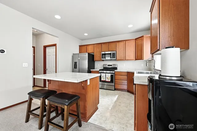 a kitchen with granite countertop a sink stove and microwave