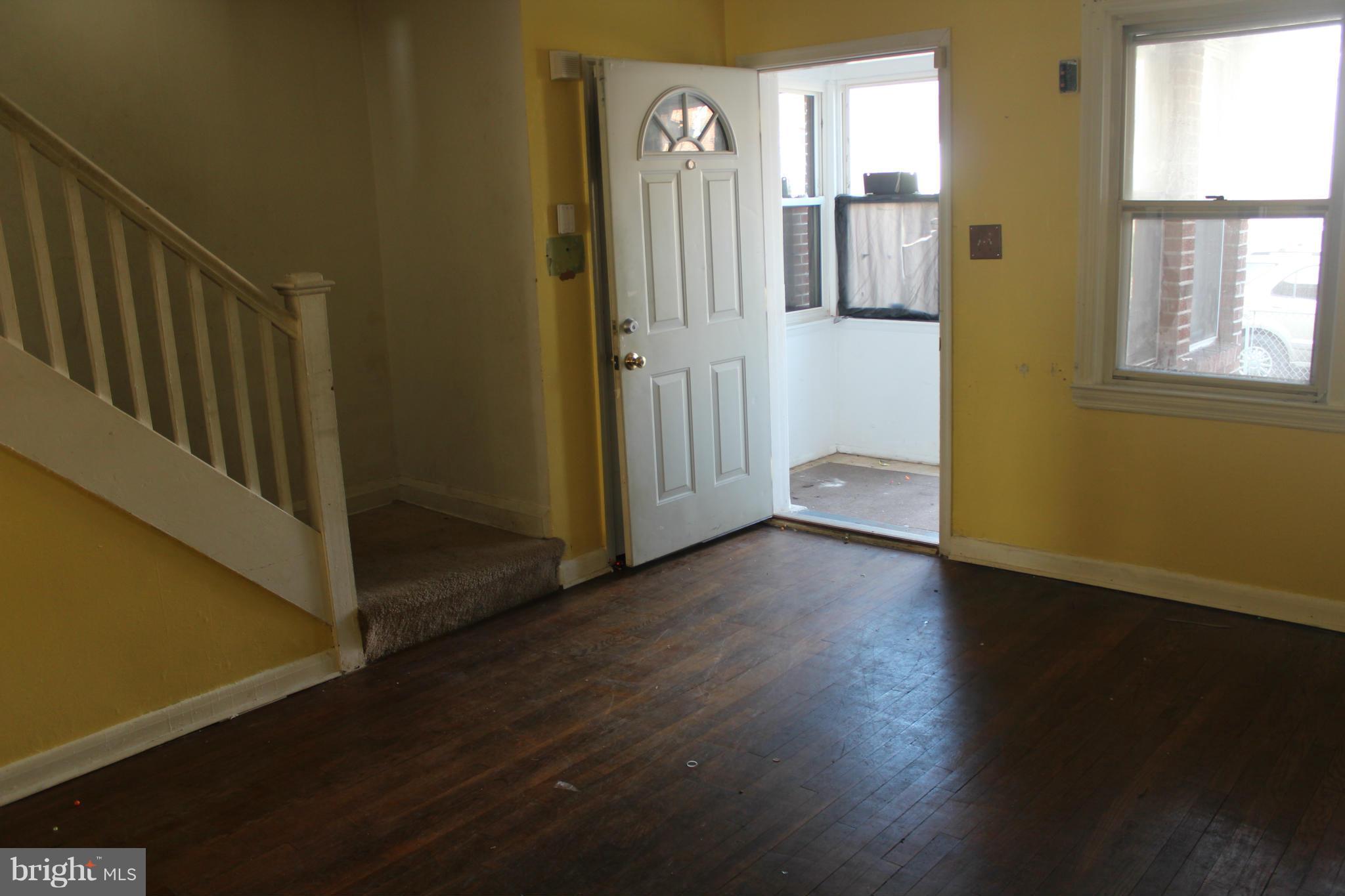 629 Roundview Road Baltimore, MD 21225 - Photo 1 of 26 a view of a hallway with wooden floor and a window