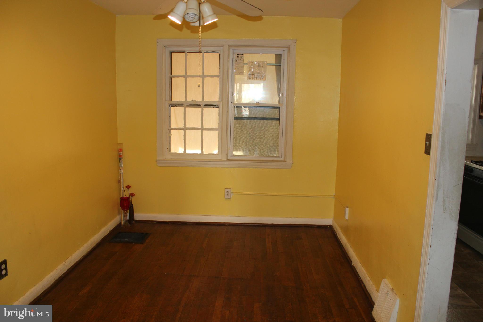 629 Roundview Road Baltimore, MD 21225 - Photo 5 of 26 an empty room with wooden floor and windows