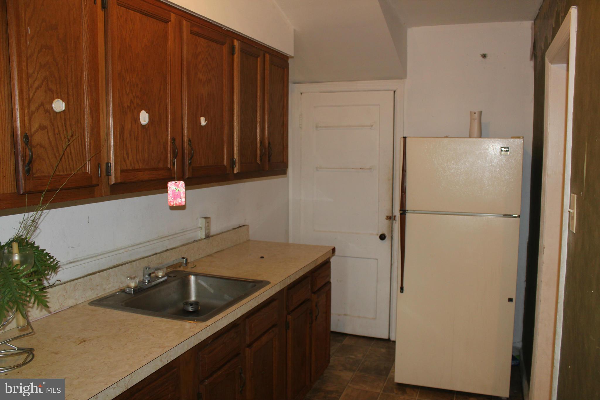 629 Roundview Road Baltimore, MD 21225 - Photo 7 of 26 a kitchen with a sink and a refrigerator