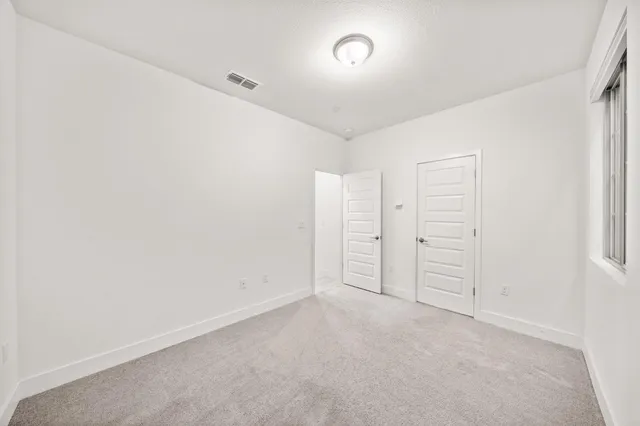 a kitchen with stainless steel appliances kitchen island granite countertop a stove a sink a refrigerator and white cabinets with wooden floor