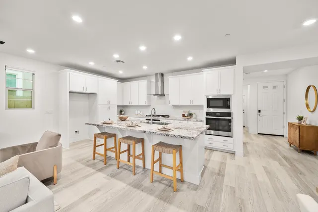 a kitchen with granite countertop stainless steel appliances a stove a sink and cabinets