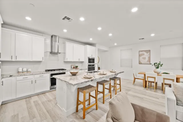 a kitchen with granite countertop a sink stove and cabinets