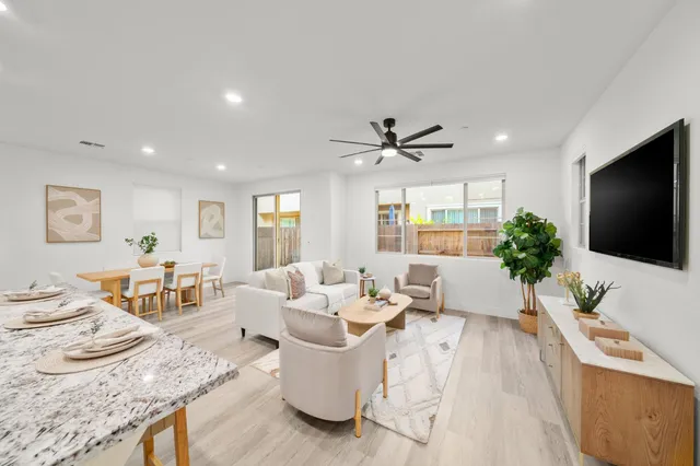 a living room with furniture and a view of kitchen