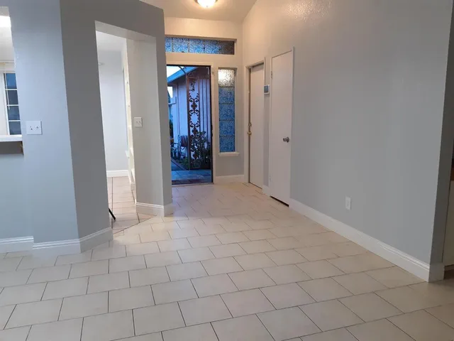 a view of a hallway with closet and a bathroom
